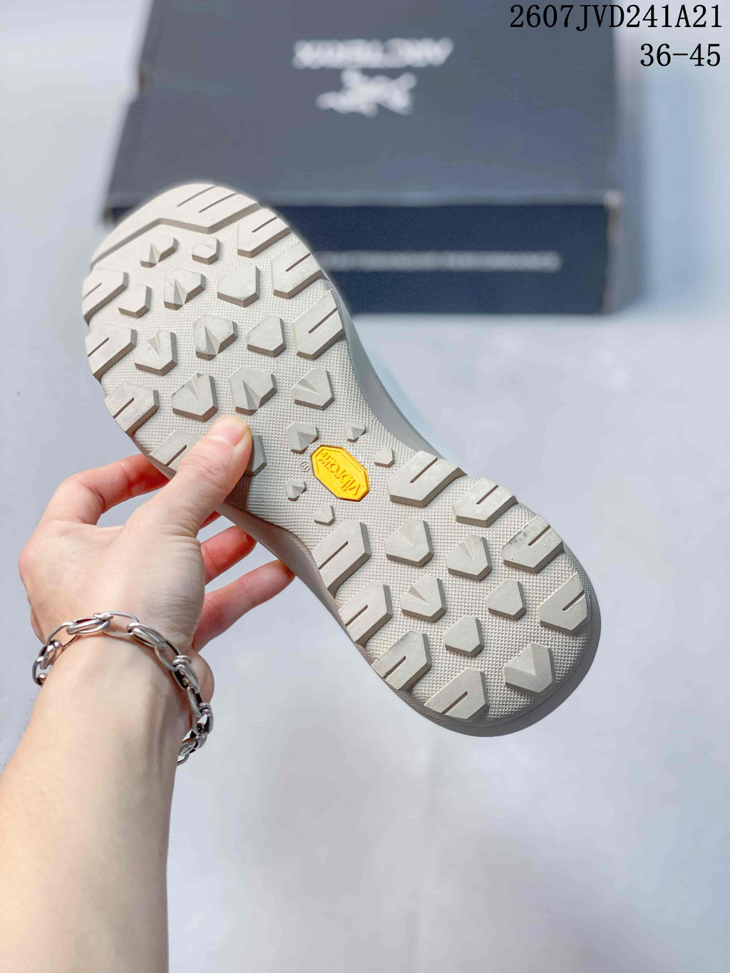Close view of the sneaker outsole showing a raised lug pattern and yellow center insert.