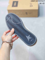 Underside view of the sneaker showing a dark outsole with a repeating zigzag tread pattern and a star-shaped detail.