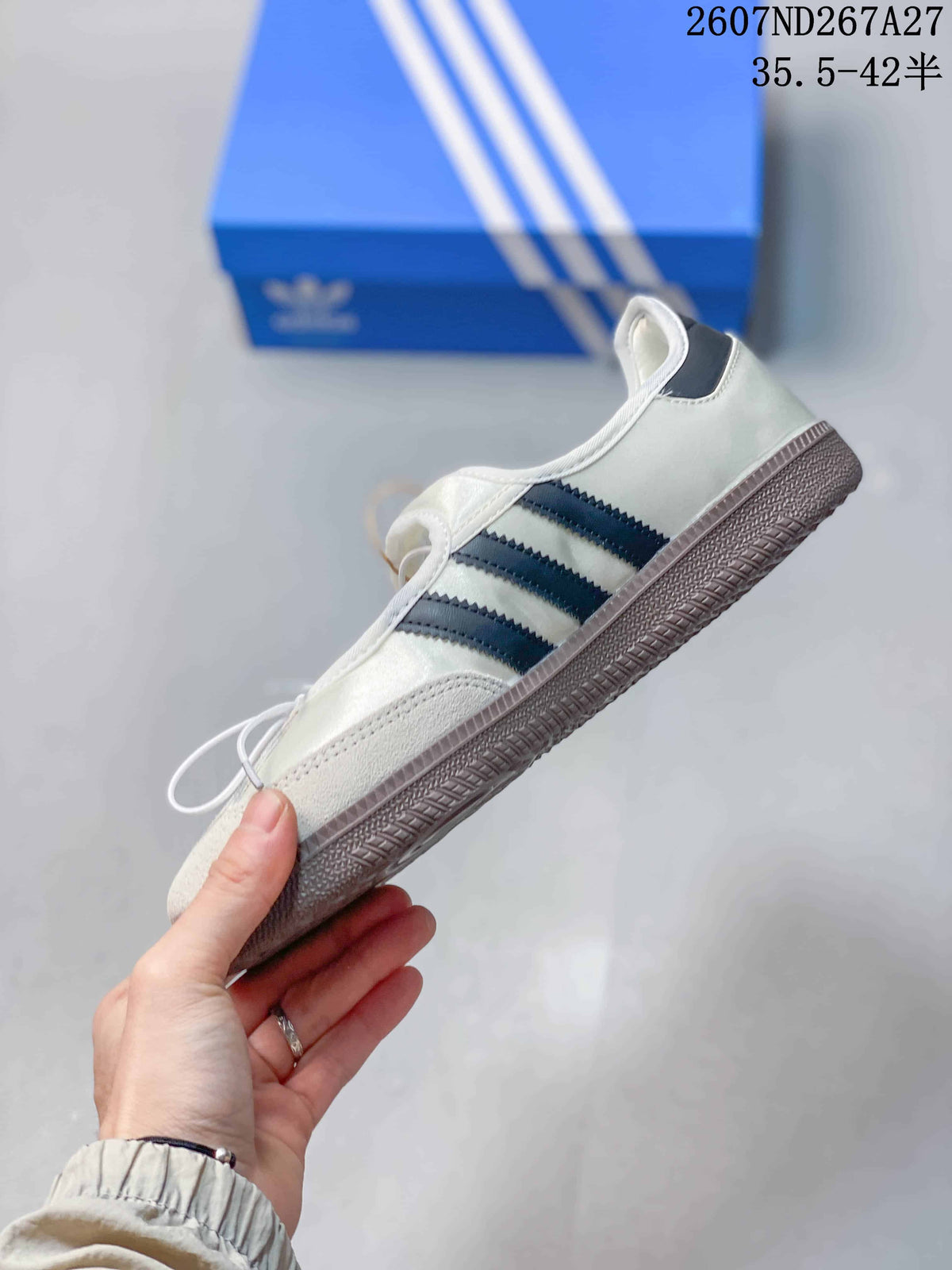 Side view of the white sneaker showing dark side stripes, lace-up construction and gum-colored sole.