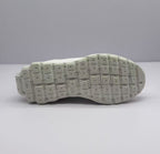 Bottom view of the sneaker outsole with a segmented geometric tread pattern.