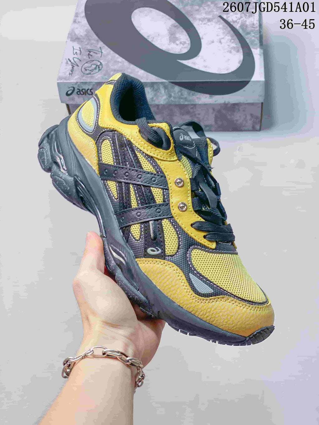 Angled side view of the yellow and charcoal sneaker