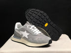 Angled view of one grey sneaker beside its raised outsole, showing the white star emblem and black lugged tread.