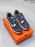 Pair of dark Nike Vomero 18 GTX running shoes displayed on an orange shoebox, showing white swooshes and bright orange and yellow midsole accents.