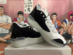 Angled view of a pair of black and white Jordan basketball shoes with lace-up fronts.