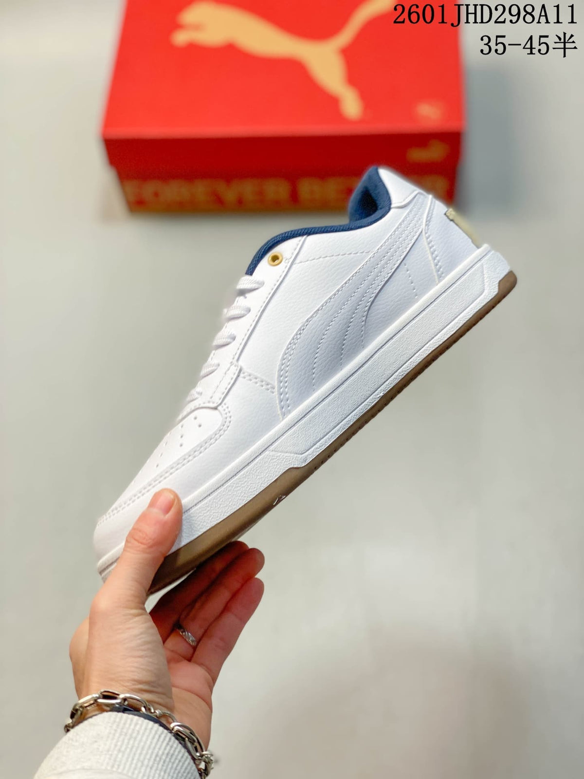 Side profile showing the white low-top sneaker, navy side stripe and gum-toned outsole.