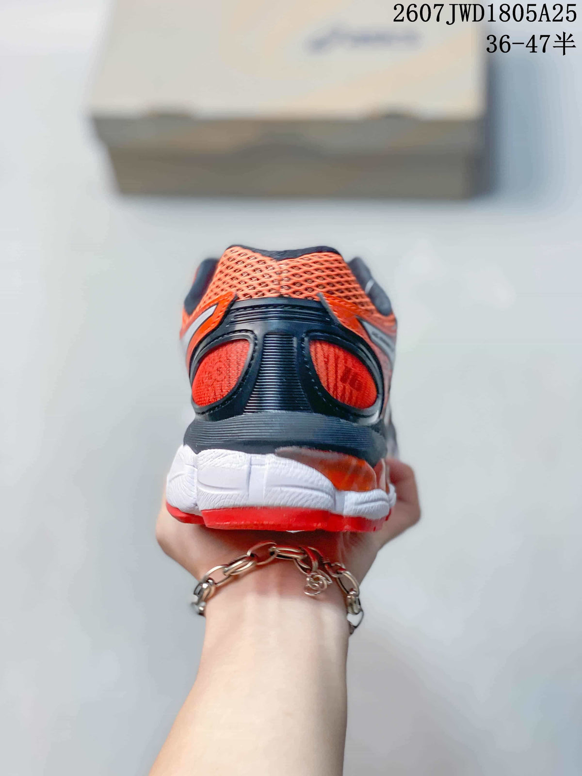 Rear view showing the black heel structure, red mesh panels, and white midsole.