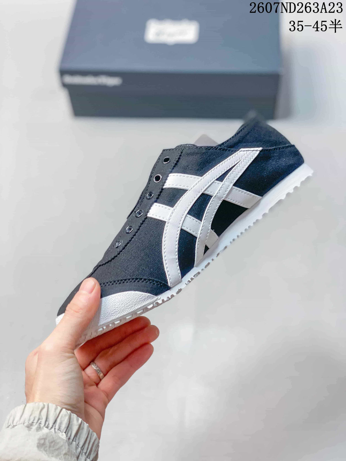 Side view of the black and white sneaker showing the contrasting stripes and textured outsole.