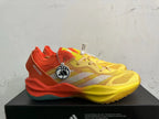 Side view of yellow and orange Adidas Adizero shoes with white stripes and a teal outsole