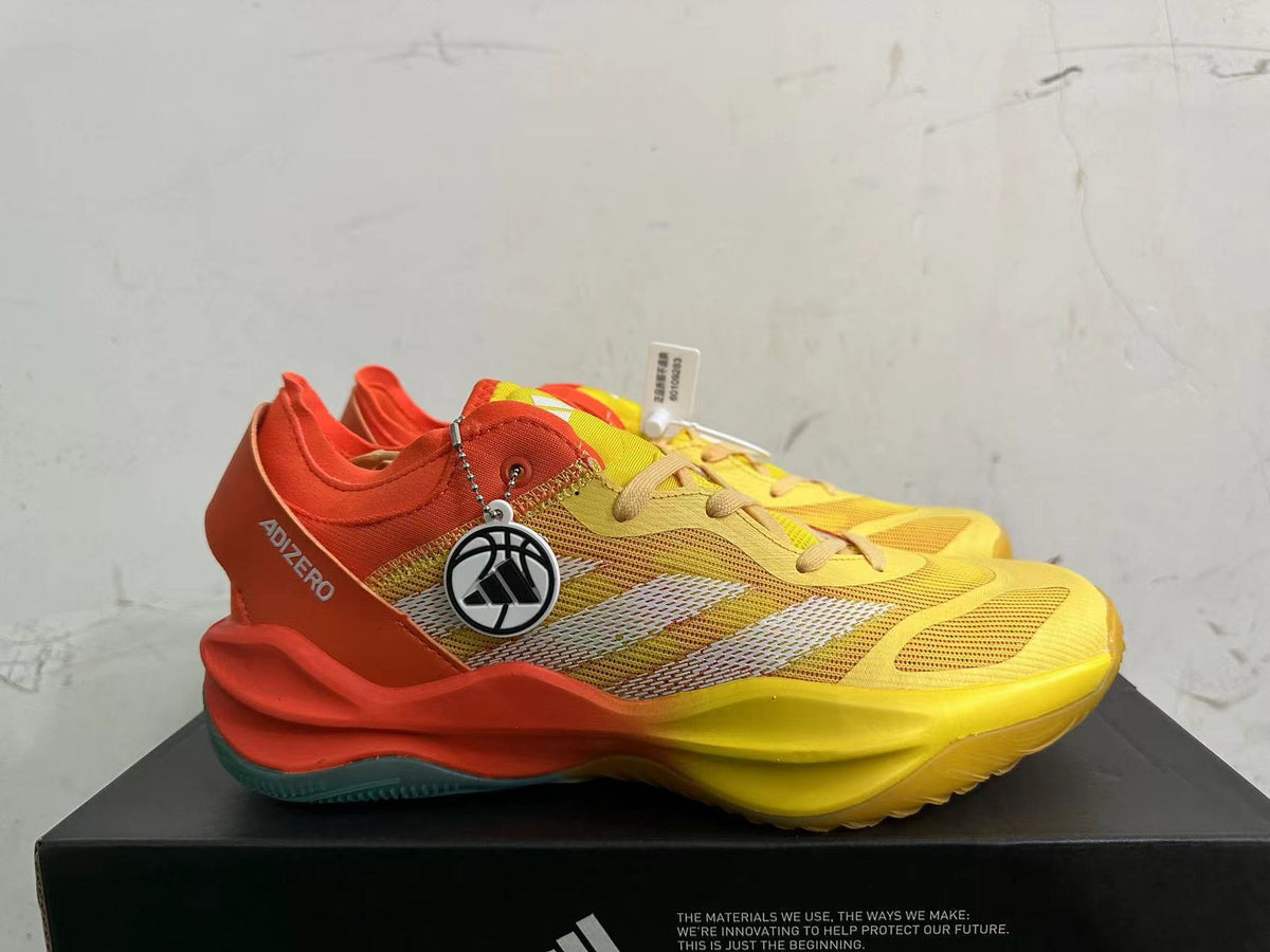 Side view of yellow and orange Adidas Adizero shoes with white stripes and a teal outsole