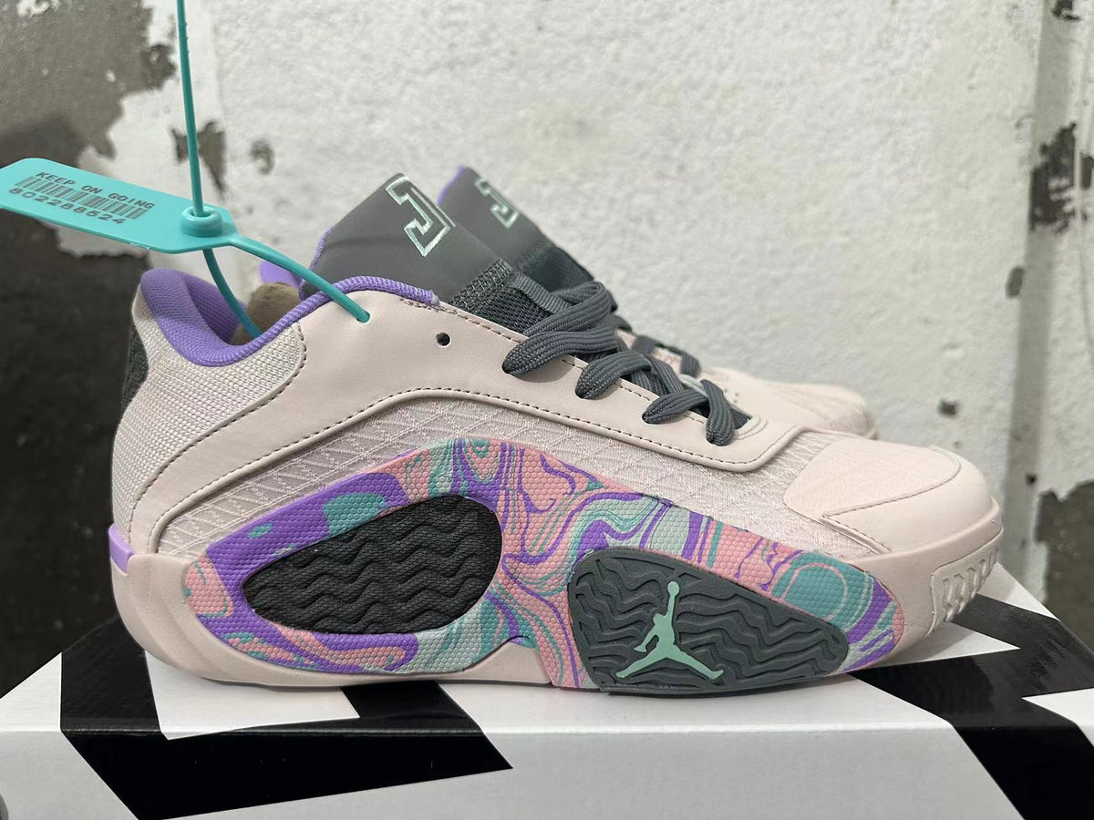 Side view showing pale pink basketball shoes with colorful patterned panels and dark gray outsole inserts.