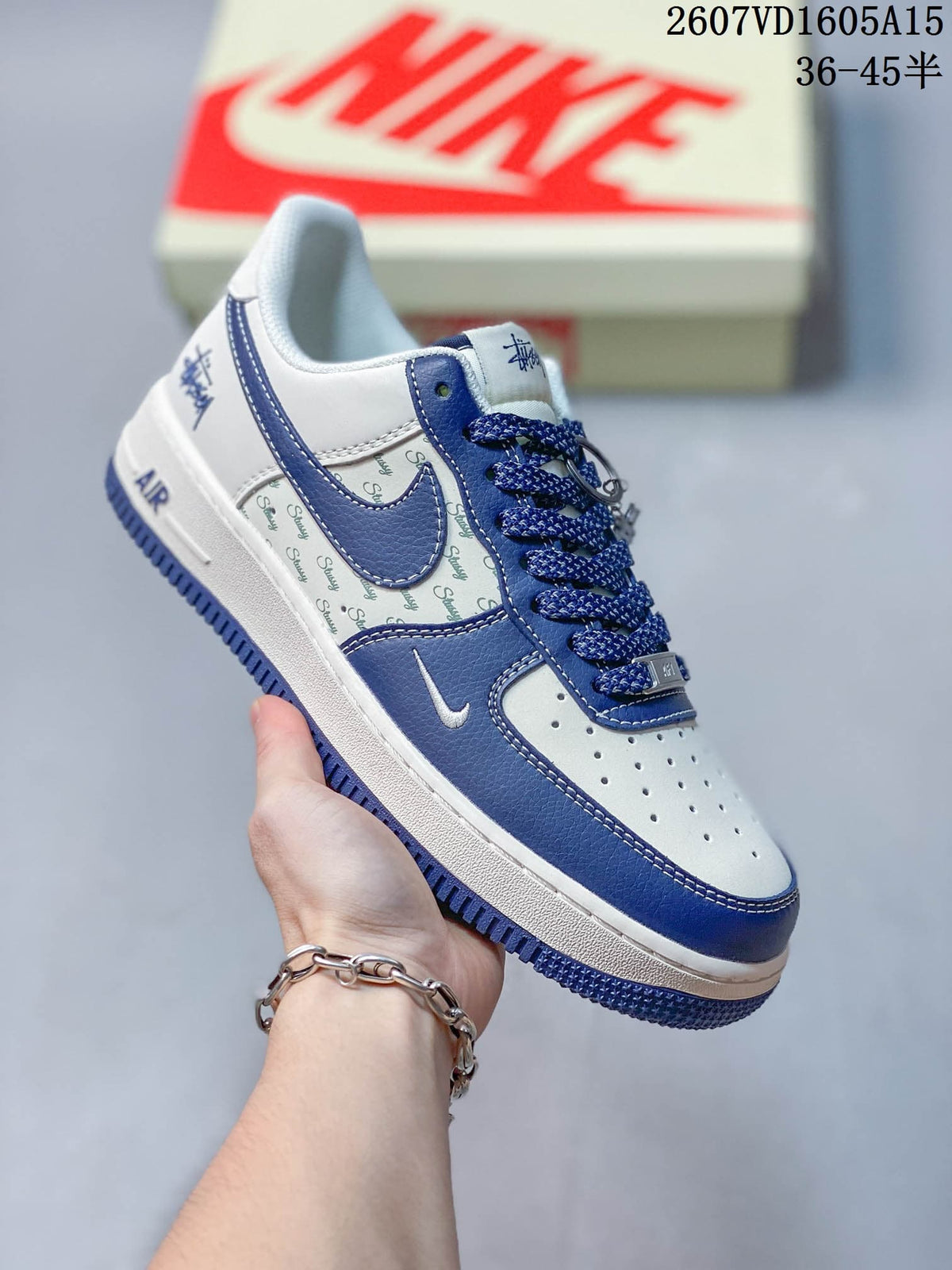 Close side view of a white and blue sneaker showing the blue outsole, patterned side panel, perforated toe box, and decorative branding.