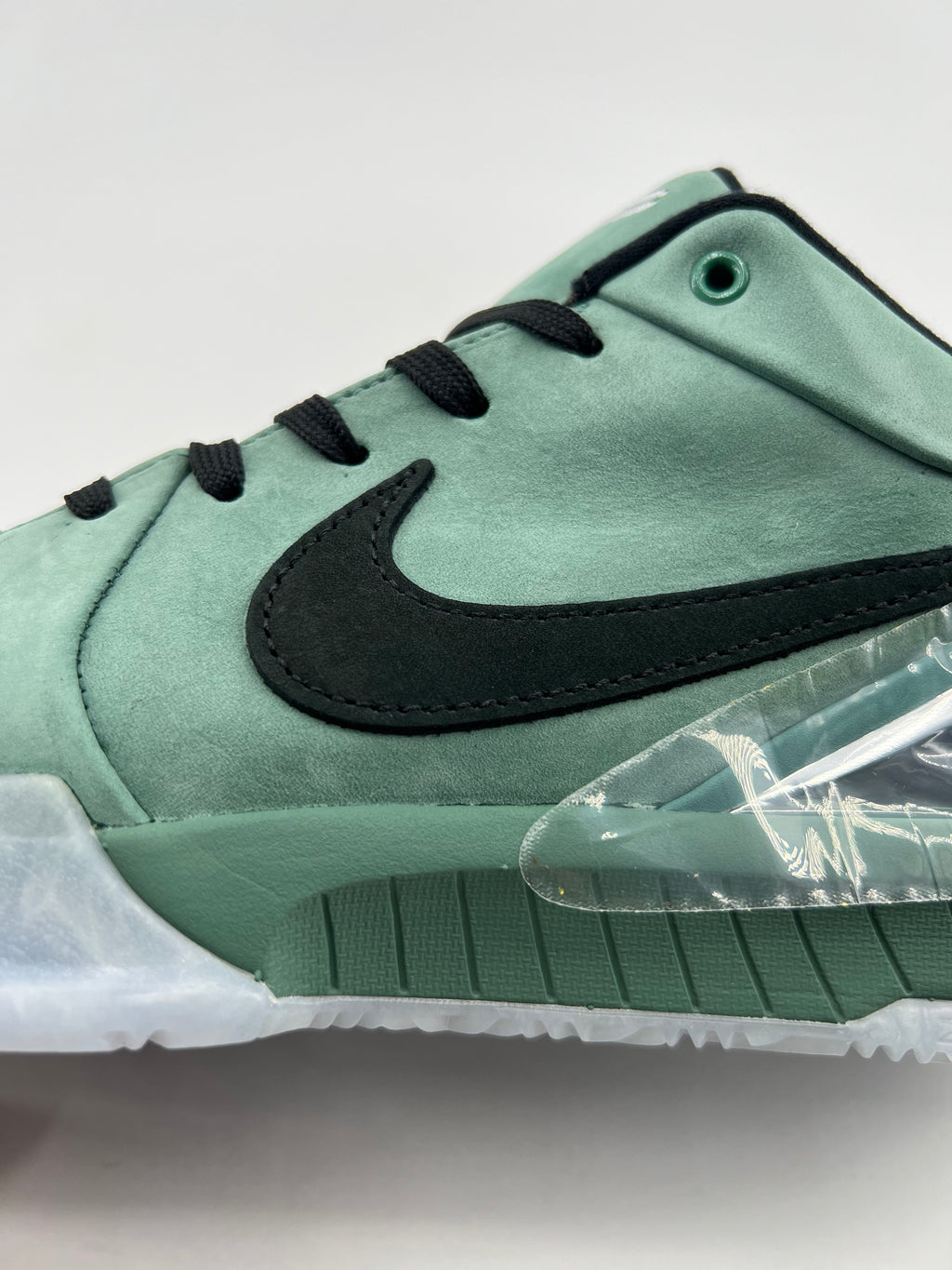Side close-up of the black Swoosh and green upper