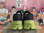 Rear view of black sneakers with lime-green soles