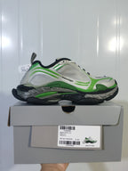 Side profile of the grey and green sneaker displayed on its box; the label shows Triple S 2, WTRS 1133, GREY MIX / GREEN MIX, and E 40.