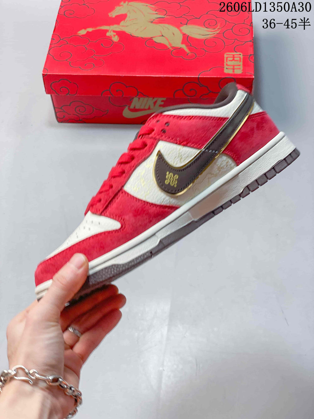 Side profile of the red and cream low-top sneaker with a dark brown side logo