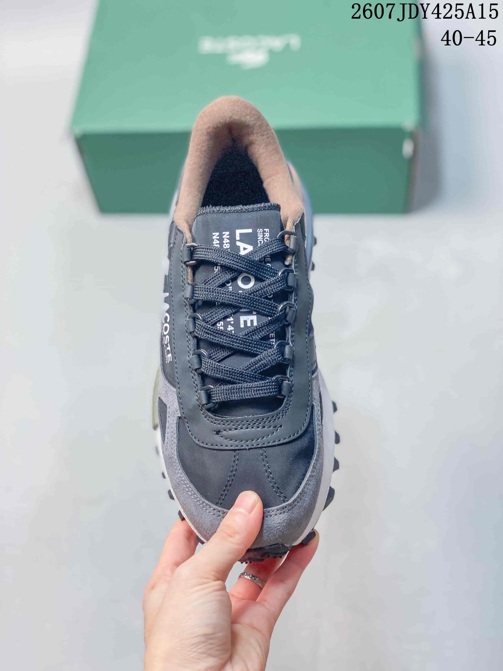 Top view of a gray lace-up Lacoste sneaker showing the rounded toe, tongue, and padded collar.