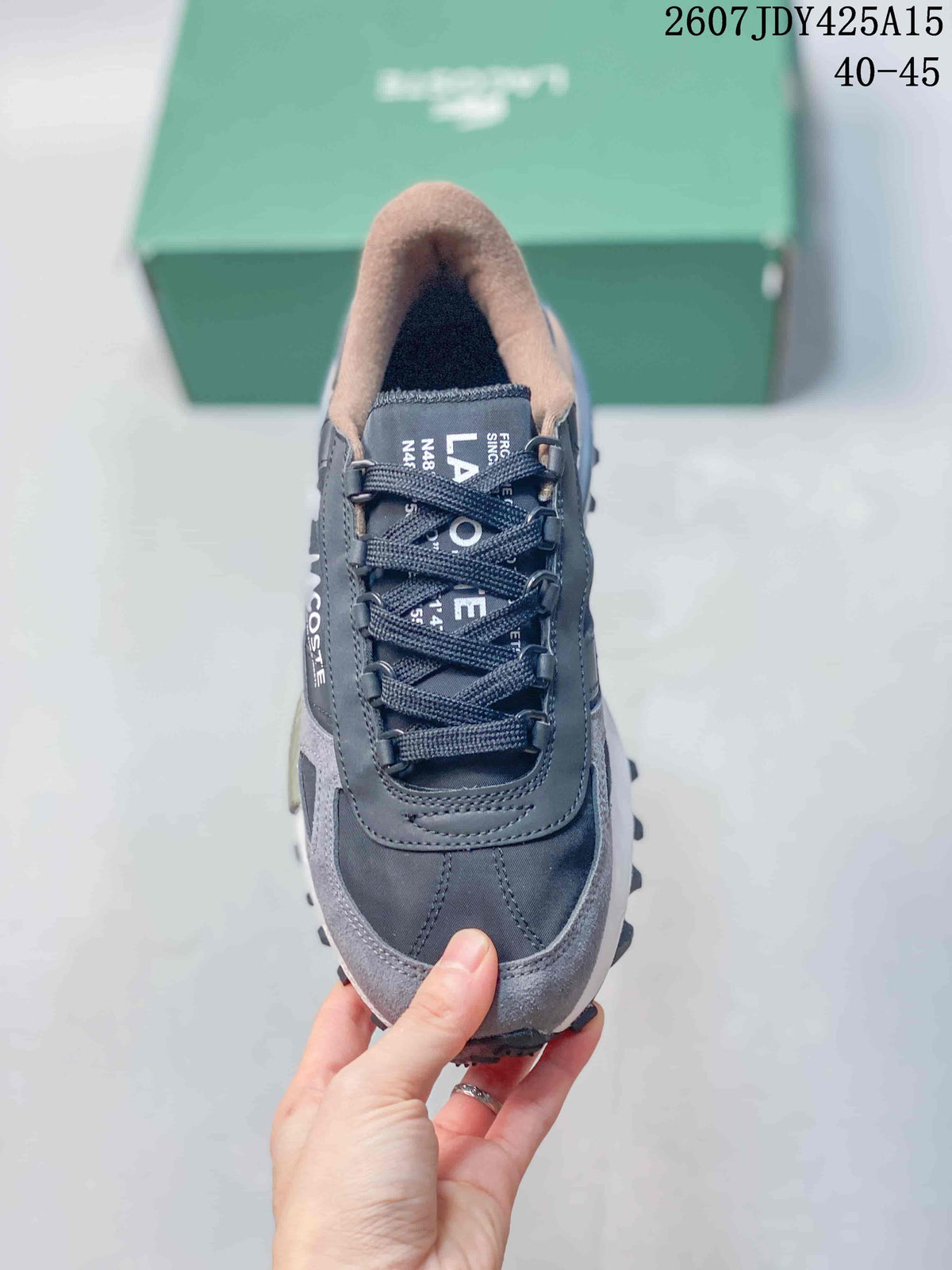 Top view of a gray lace-up Lacoste sneaker showing the rounded toe, tongue, and padded collar.