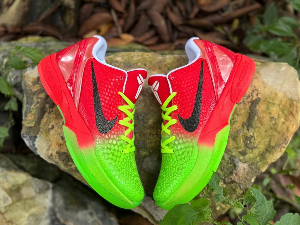 Front-facing pair of red and bright green basketball shoes with black Swooshes