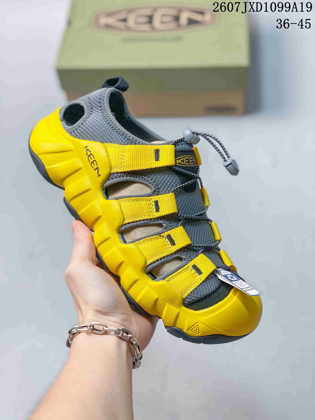 Yellow and dark gray Keen sandal with adjustable webbing straps, quick-lacing hardware and a protective toe bumper; the image includes the size range 36–45.