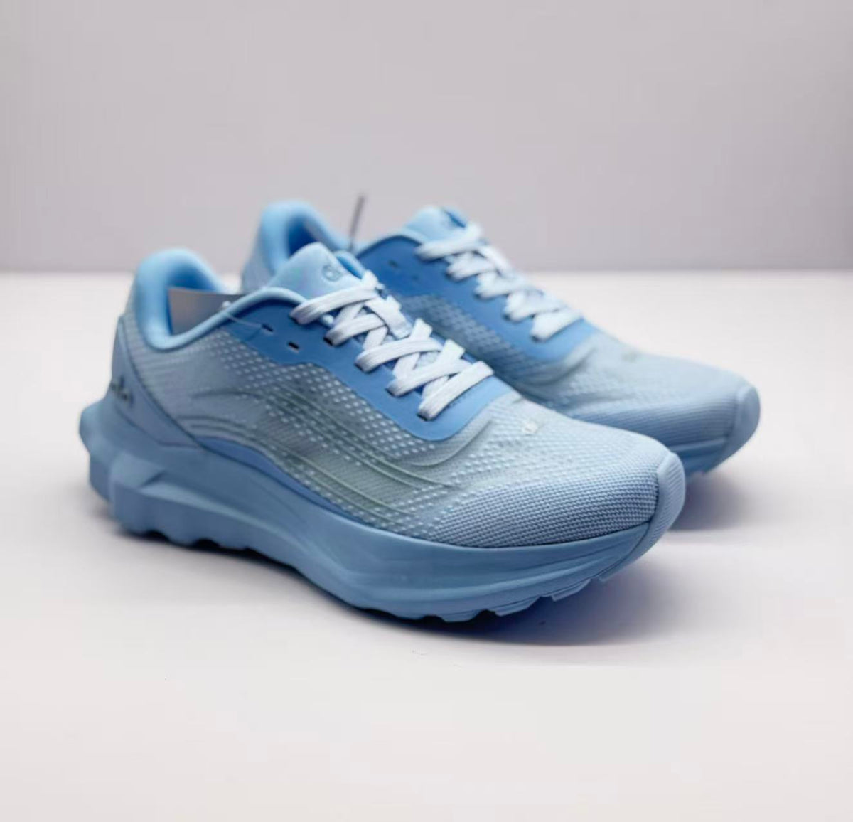 Pair of light blue Alo sneakers shown from a front three-quarter angle.