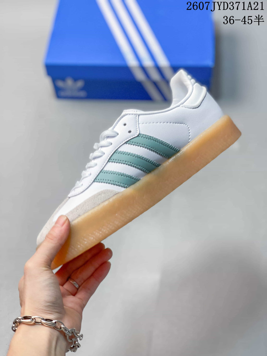 Side profile showing the white upper, mint-green three stripes, gray toe detailing, and gum sole.