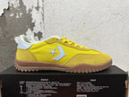 Side view showing yellow Converse training-style shoes with star-and-chevron emblems and gum-colored outsoles.