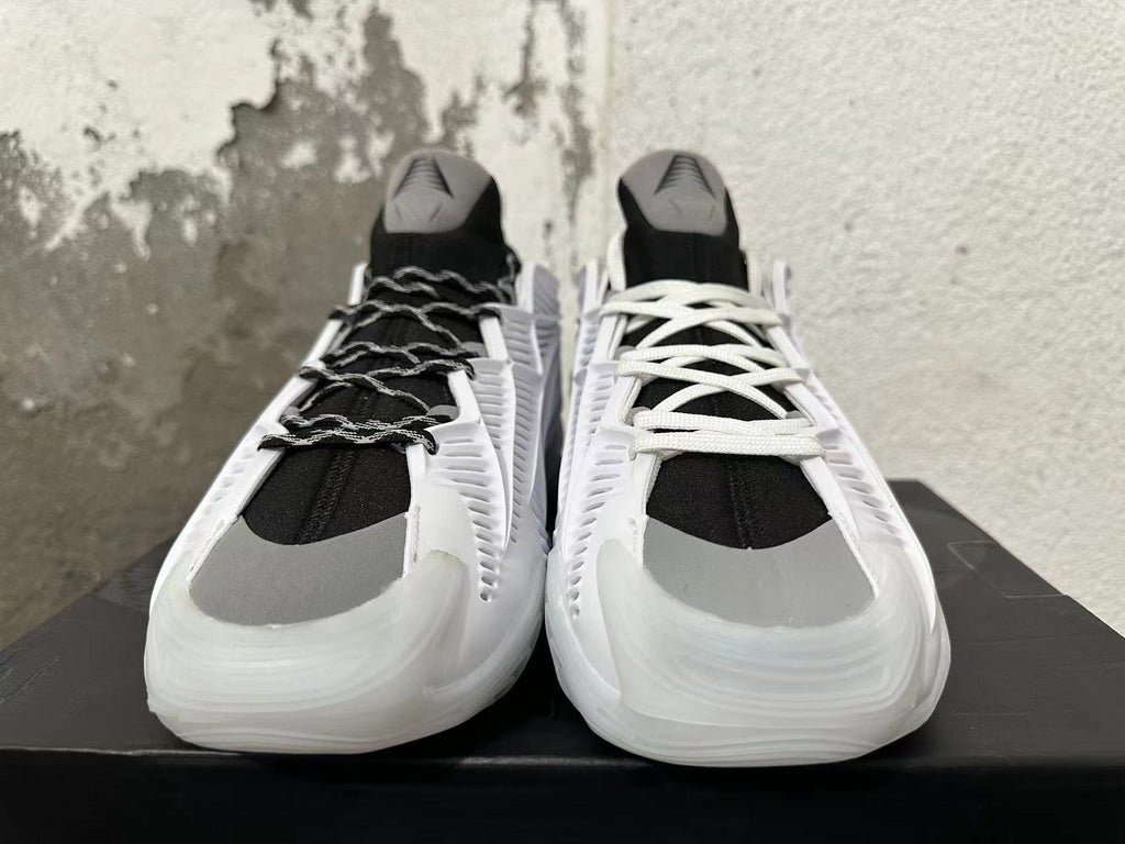 Front view of white and black sneakers with gray toe accents and contrasting lace options