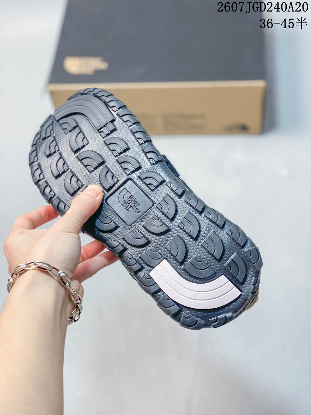 Close view of the sandal outsole showing a deep, textured tread pattern and a central branded section.