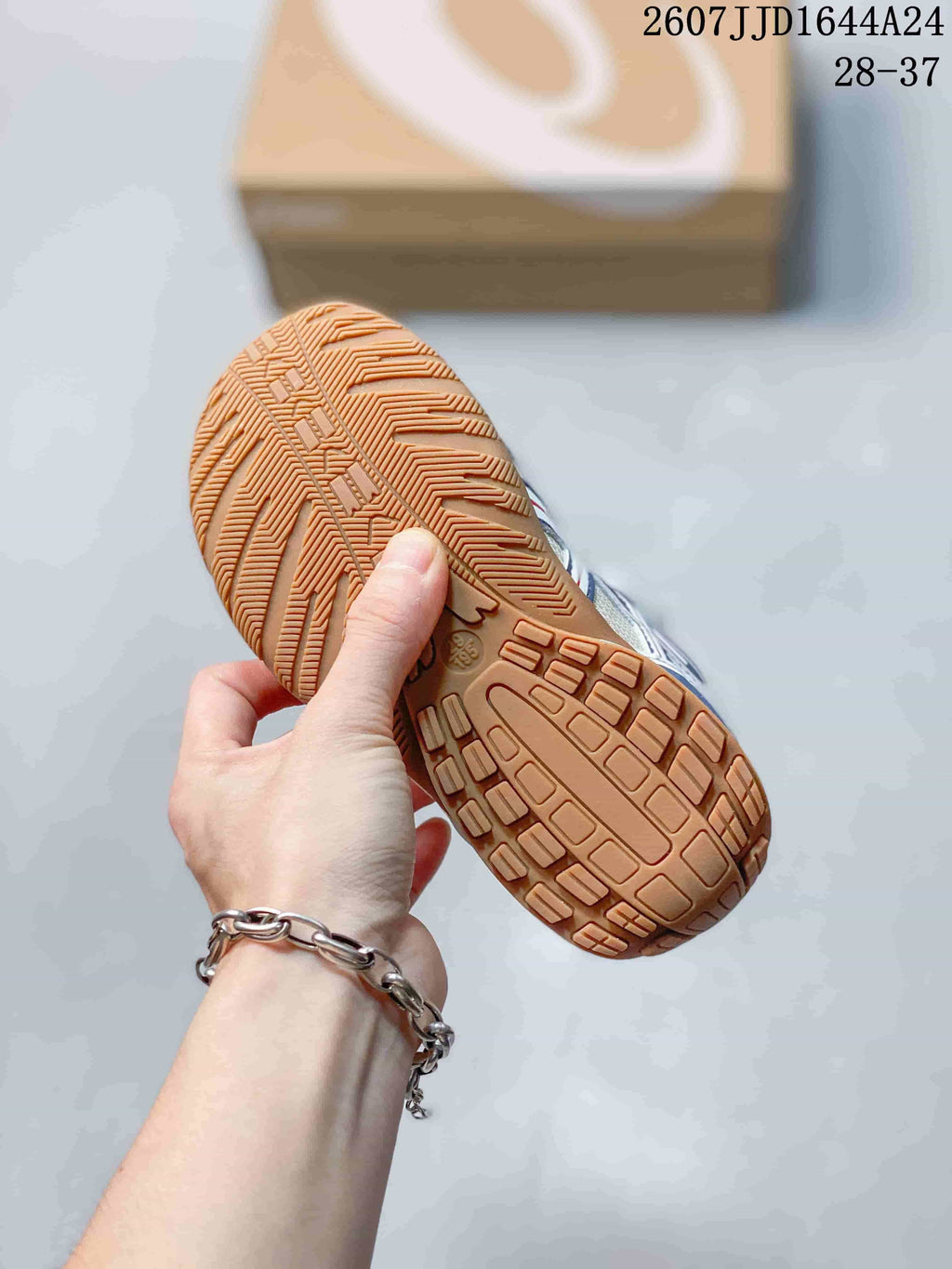 Close view of the textured gum-colored outsole on an ASICS HYPERSYNC sneaker.