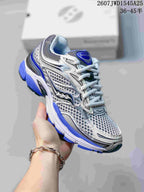 Angled side view of a Saucony ProGrid Omni 9 sneaker showing the white, gray and blue upper and layered sole.