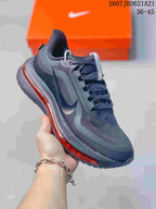 Angled side view of the Nike sneaker showing the black and charcoal upper, side Swoosh, patterned laces, and red midsole accent.