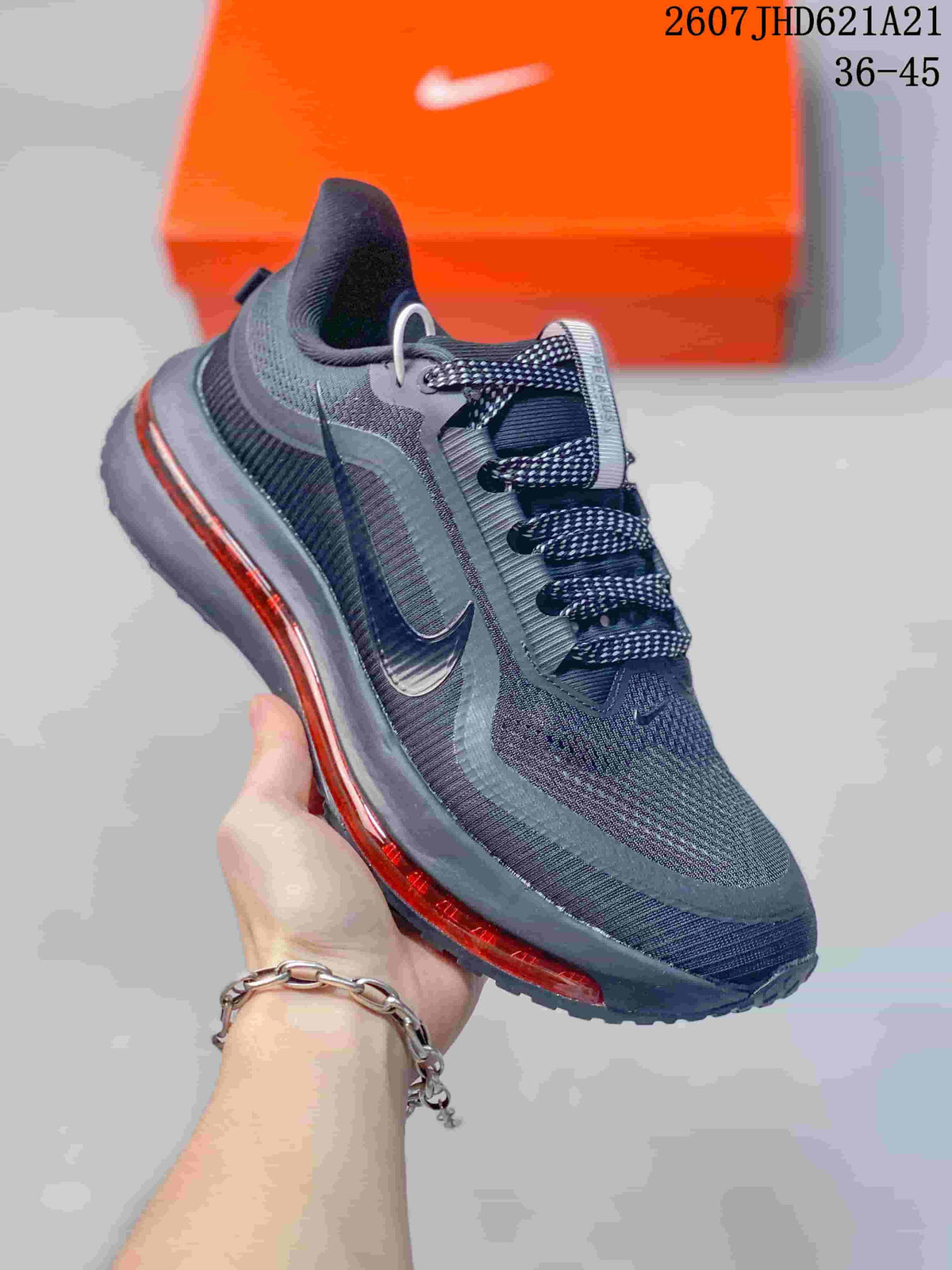 Angled side view of the Nike sneaker showing the black and charcoal upper, side Swoosh, patterned laces, and red midsole accent.