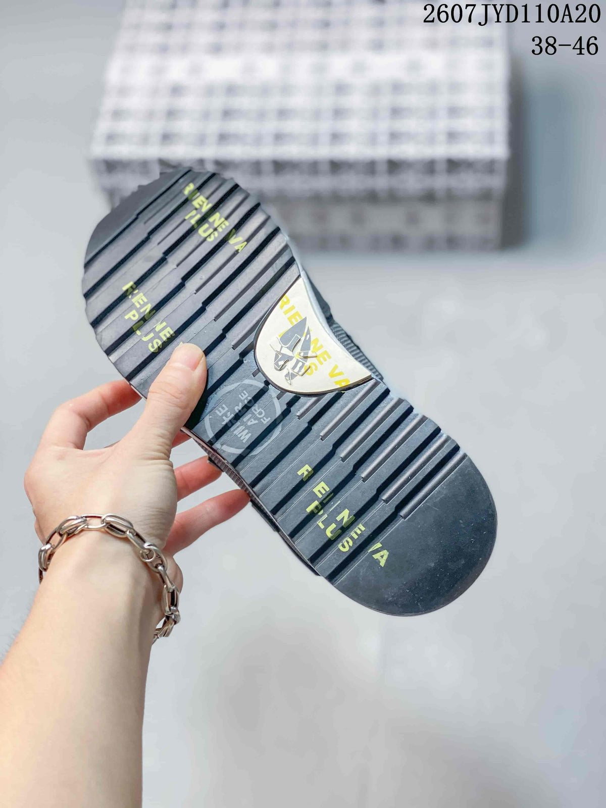 Close view of the sneaker outsole showing a ridged tread pattern and printed graphic details.