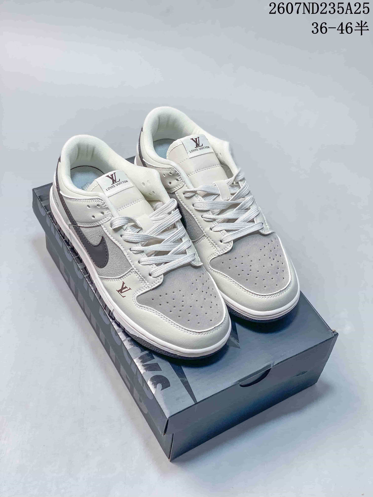 Pair of white and grey low-top sneakers displayed on a branded shoe box, with dark swooshes and contrasting tongue marks visible.