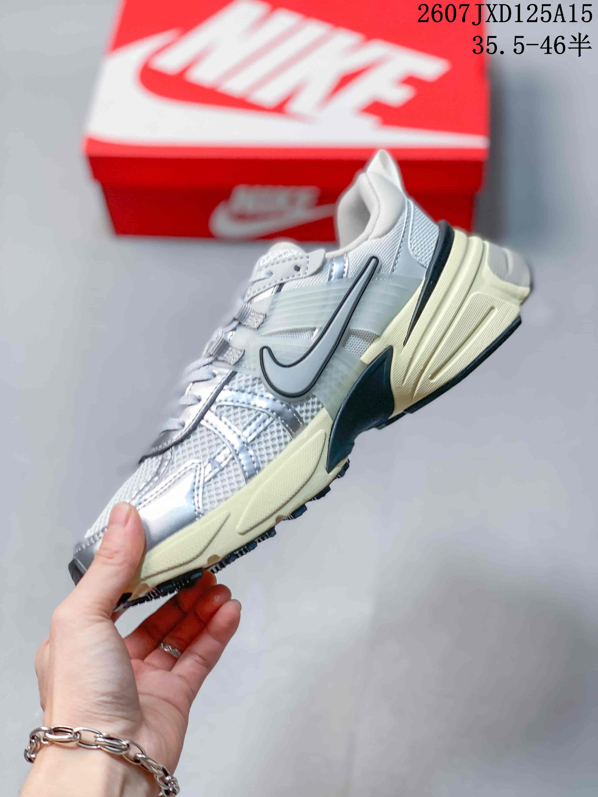 Side view of the Nike V2K sneaker showing the large side Swoosh, mesh panels, layered overlays and chunky cream midsole.