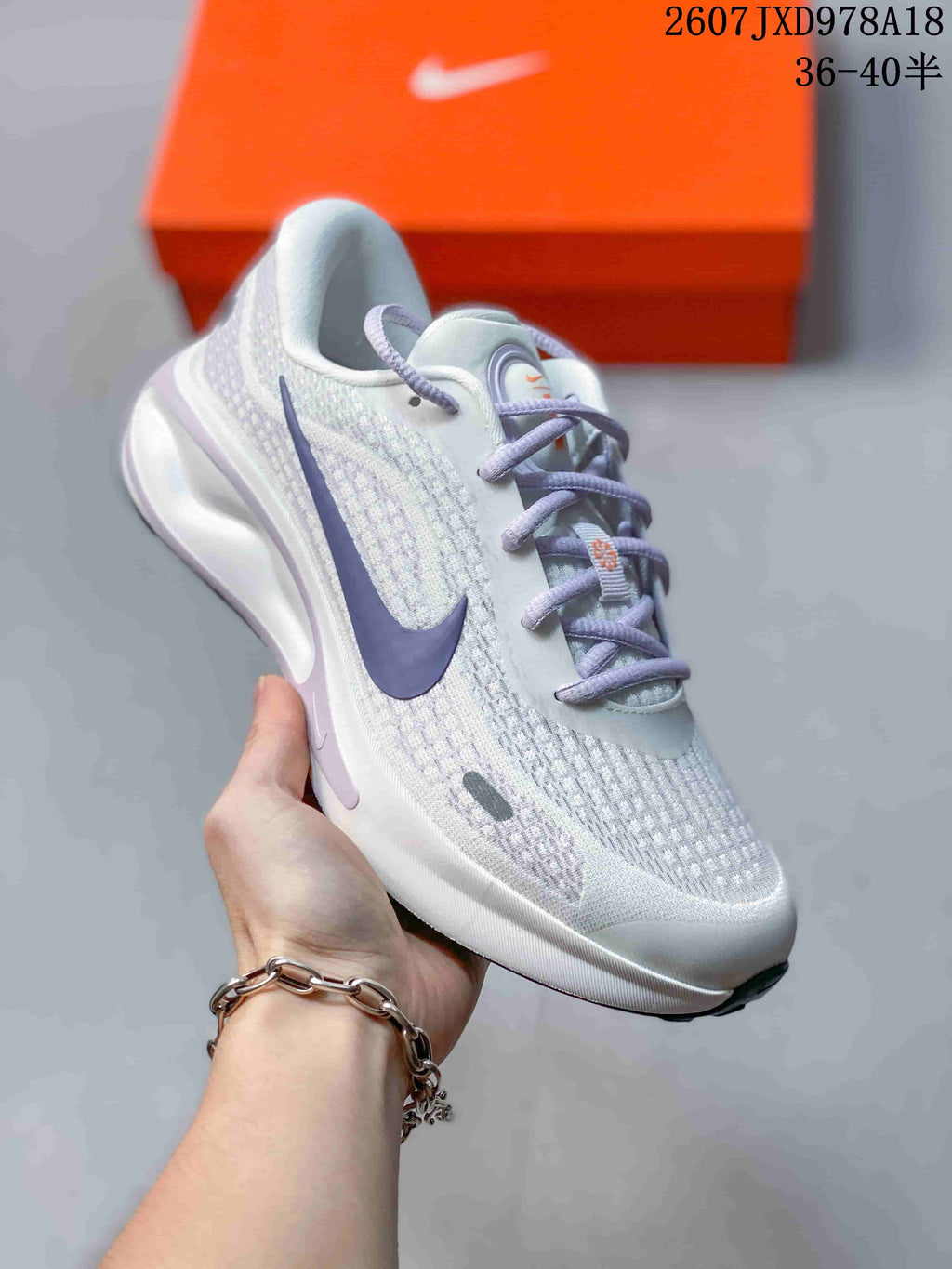 Light Nike Journey Run sneaker with a purple logo, lavender laces, and patterned textile-style upper.