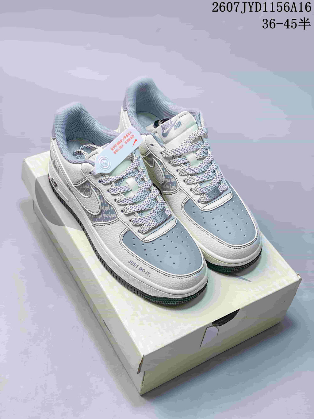 White and grey low-top sneakers with patterned side panels, grey toe boxes, and patterned laces.