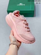 Close side view of a pink Lacoste sneaker and thick sole