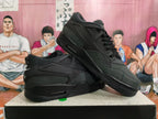 Pair of black Nike sneakers displayed at an angle, showing the side panels and heel branding.