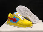 Angled view of the yellow sneakers with one shoe lifted to show the white outsole’s star and geometric tread pattern.