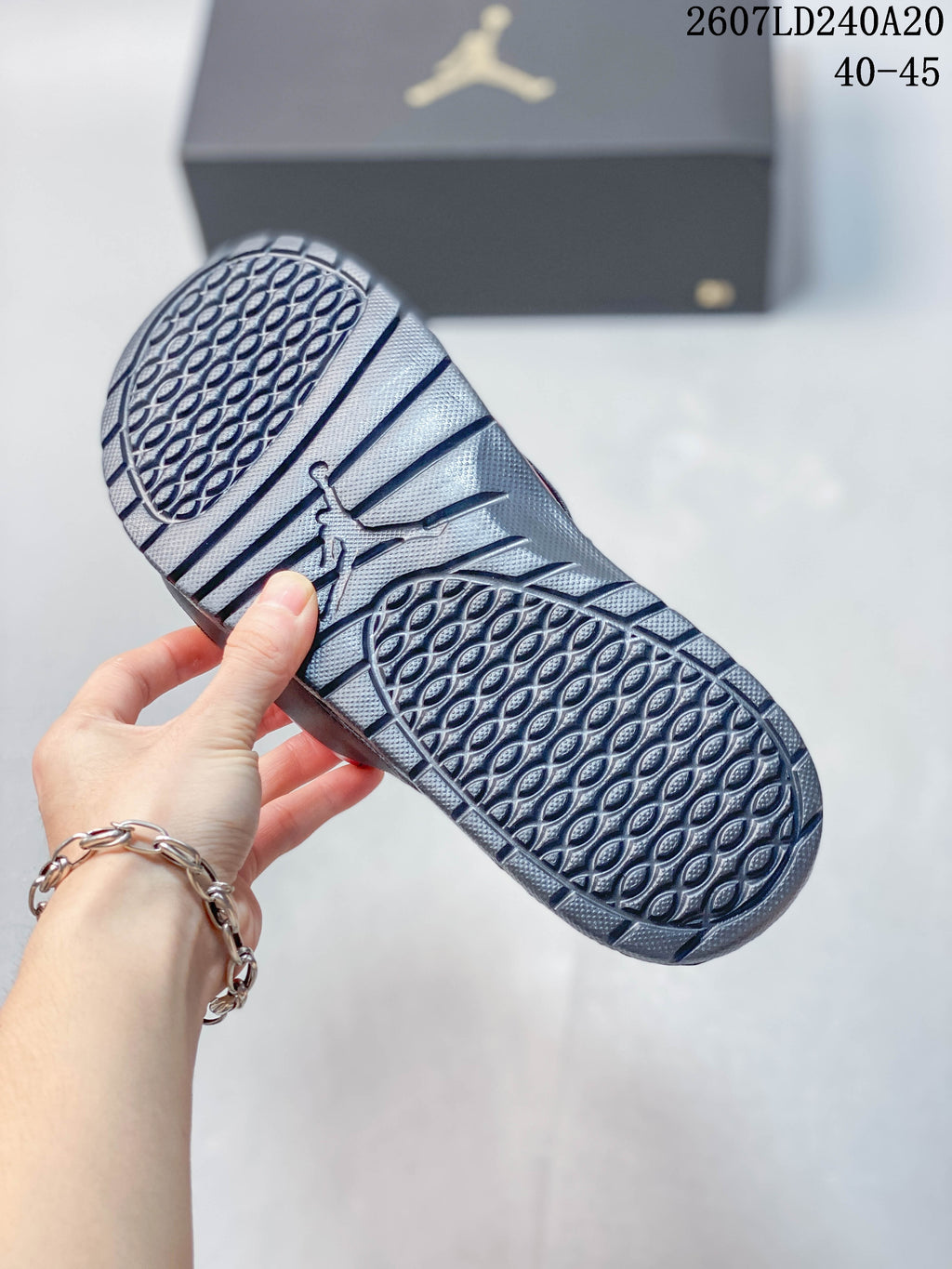 Underside of a Jordan slide showing the patterned black outsole tread and central Jordan logo.