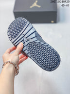 Underside of a Jordan slide showing the patterned black outsole tread and central Jordan logo.