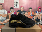 Side profile showing black sculpted panels and a gold-tone midsole detail.