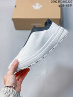 Side view showing the white low-cut slip-on profile and textured upper.
