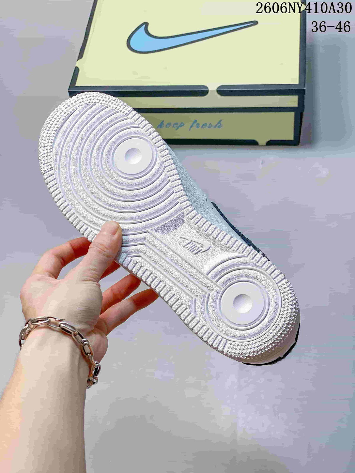 Underside of the white sneaker showing its circular tread pattern
