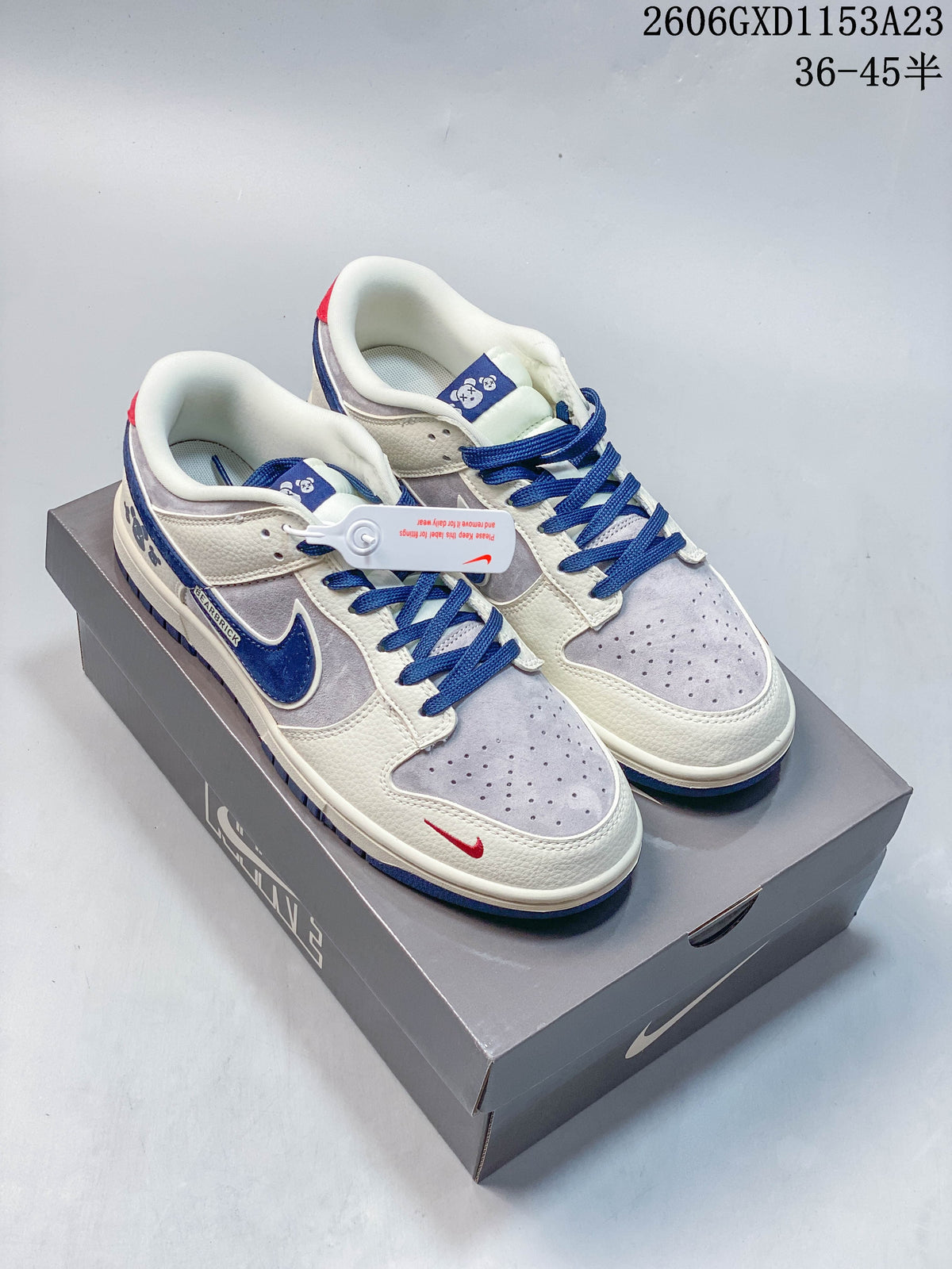 Pair of cream, pale gray, and blue Nike SB Dunk low-top sneakers on a box