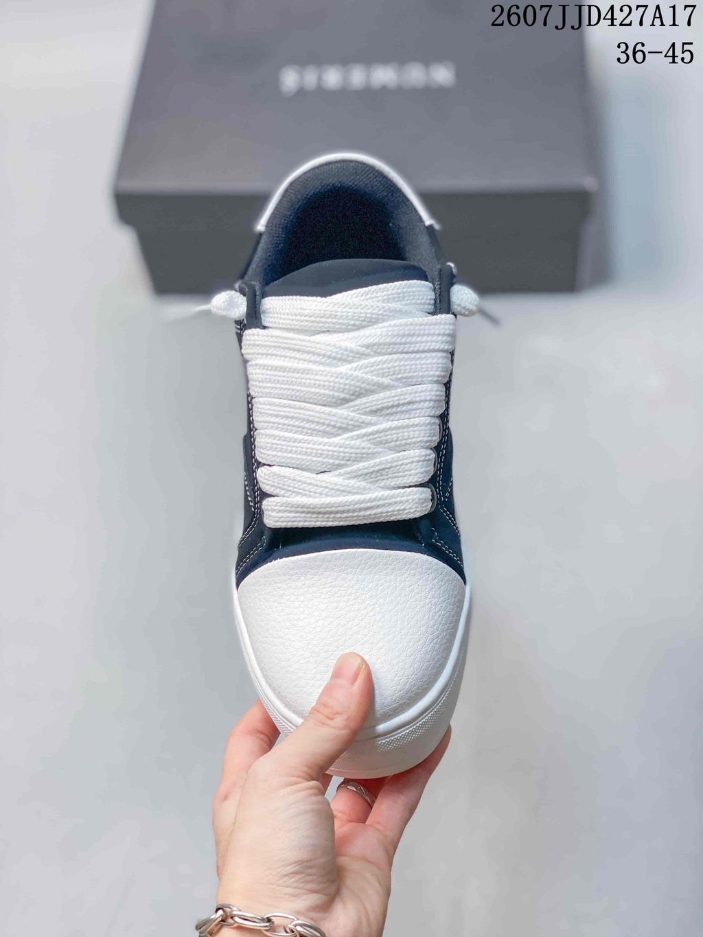 Top view of a Numeris sneaker showing the white toe panel, wide white laces, and navy upper.