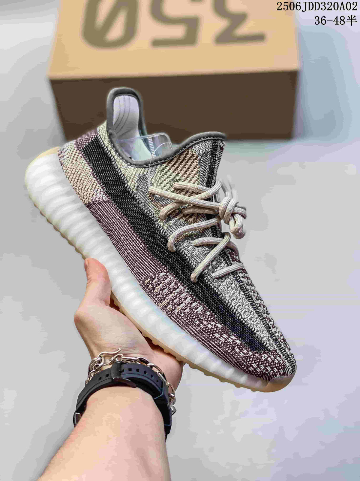 Light gray and beige knit sneaker with a black side stripe, light laces, and a white ribbed sole.