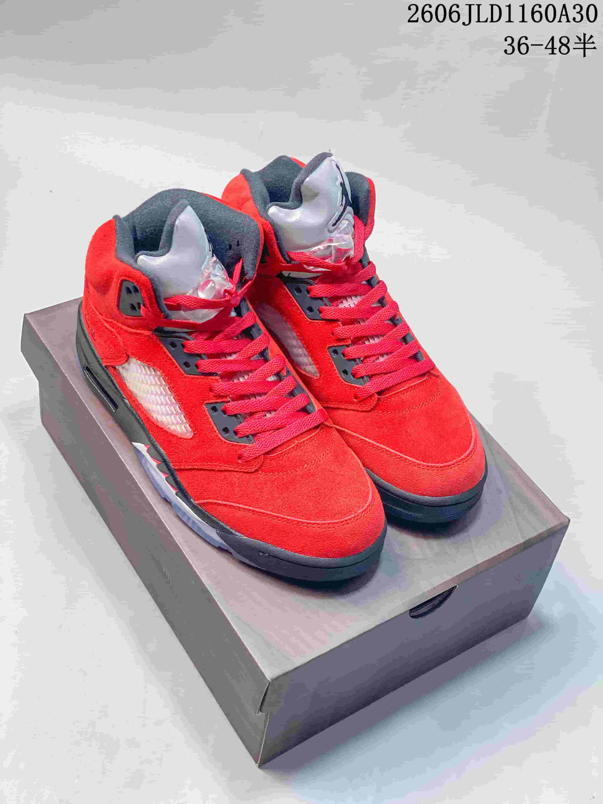 Red and black Jordan 5 high-top sneakers shown on a box from the front.