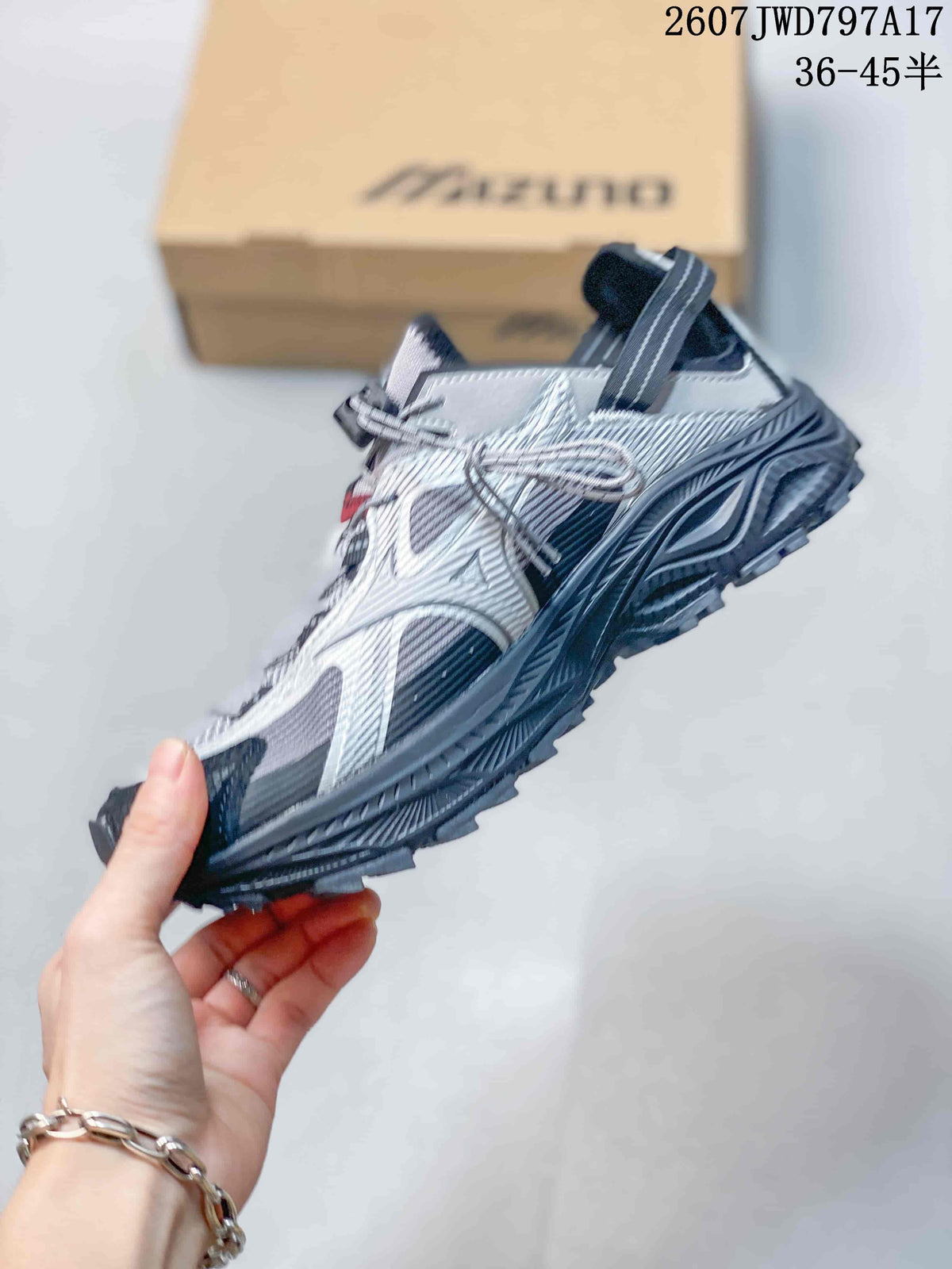 Side view highlighting the layered silver upper, dark panels and rugged outsole of the Mizuno sneaker.